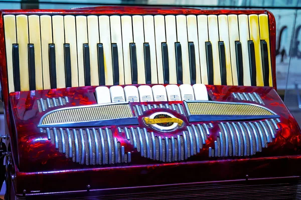 The old rare red accordion . Buttons and keyboard close up view.