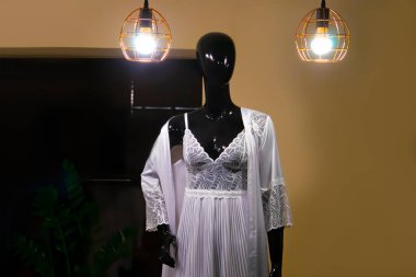 Bir mankenin üzerinde beyaz gecelik ve bornoz