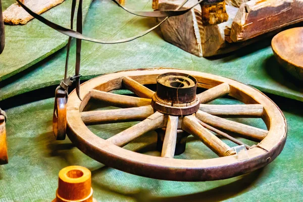 antique wooden wheel of carriage isolated on an old wall