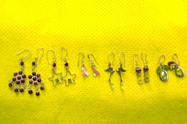 Sarı arka planda saf gümüş küpeler.