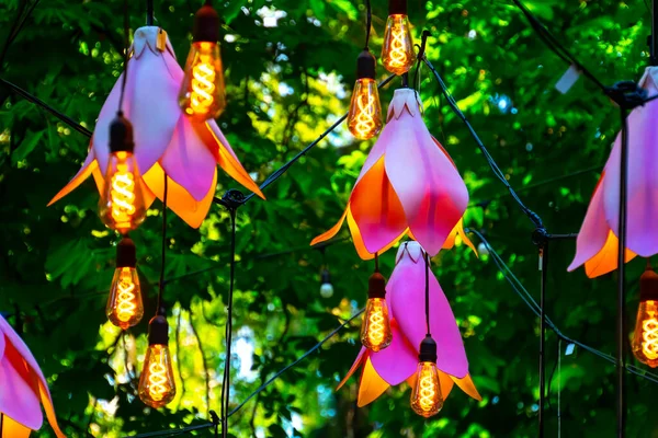 庭に電球と人工の花を持つクローズアップガーランド — ストック写真