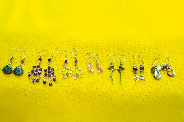Sterling silver earrings on yellow background
