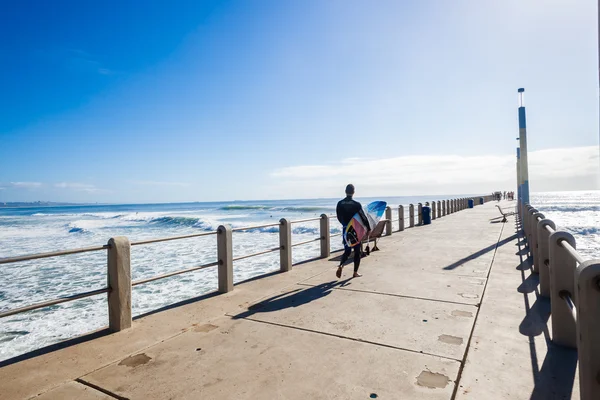 Surfista cammina molo oceano salto — Foto Stock