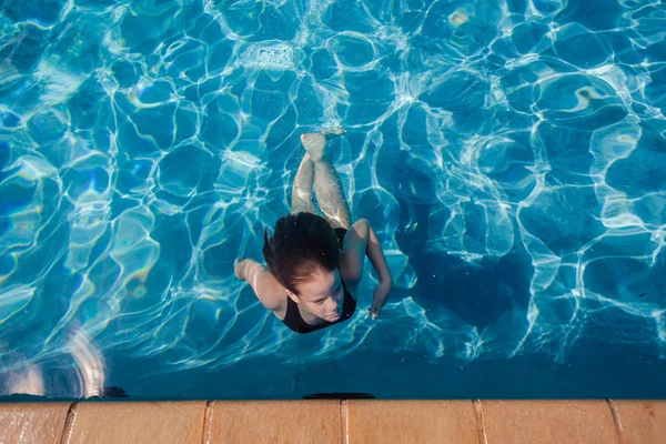 Chica nada superficie piscina submarina —  Fotos de Stock