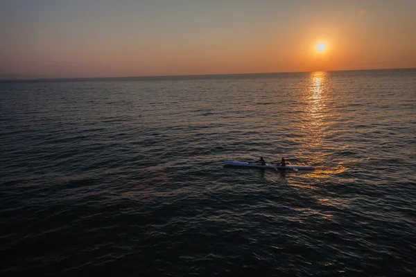 Surf-ski paddlare ocean reflektioner sunrise — Stockfoto