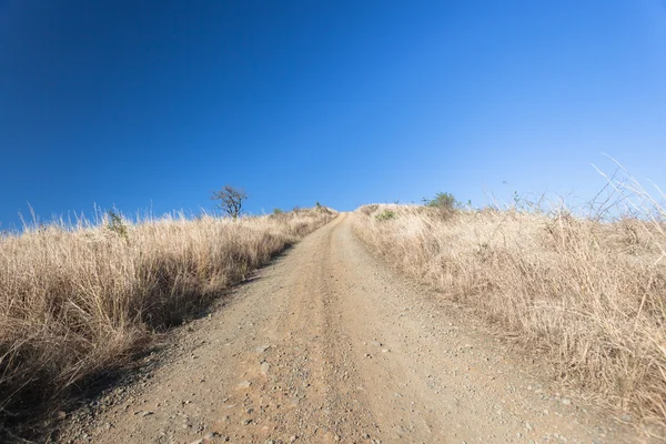 Onverharde weg steile blauwe terrein — Stockfoto