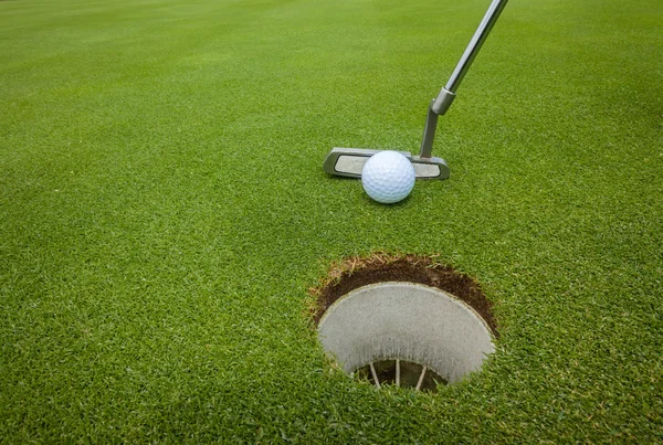 Golf putter bollen hål — Stockfoto