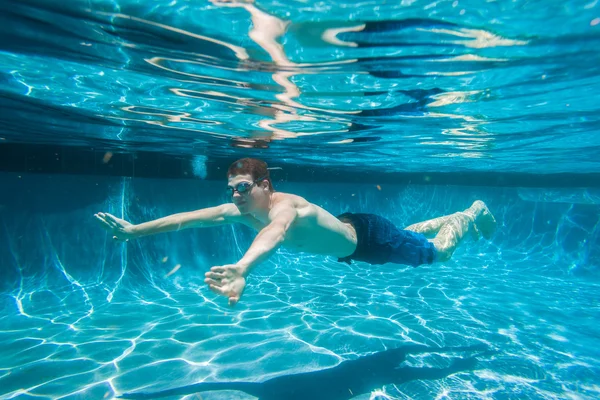 Adolescente chico bajo el agua piscina verano — Foto de Stock