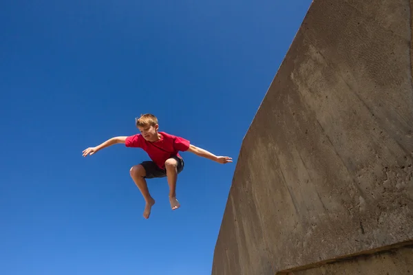 Adolescent garçon saut bleu ciel parkour — Photo