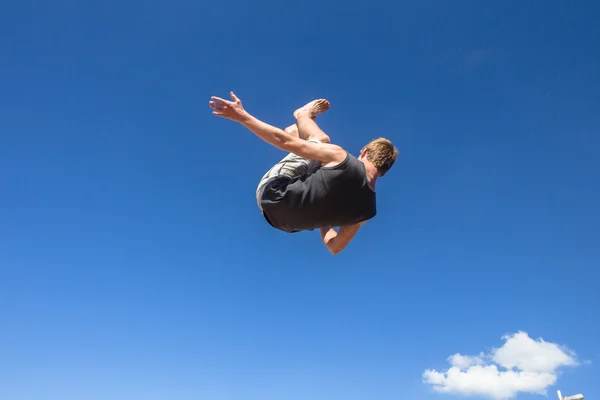 Jongen parkour springen salto's blauw — Stockfoto