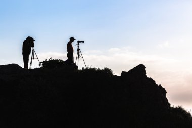 niebo sylwetki fotografów