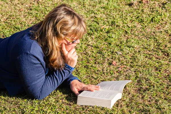 Vrouw boek lezing gras — Stockfoto