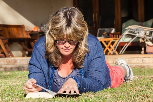 Vrouw boek lezing gras — Stockfoto