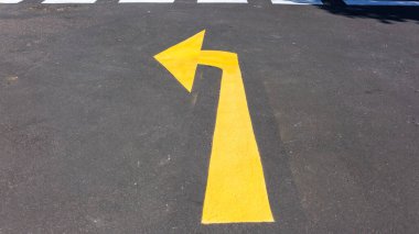 Araç trafiği için kavşak içi bölümündeki asfalt asfalt asfalt asfalt pistinde rota için yol taze sarı ok işareti.