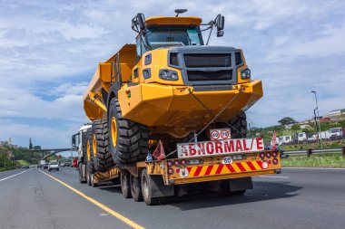 Yeni büyük maden kamyonu inşaatı. Anormal nakliye karavanı nakliye güzergahında toprak işi aracı..