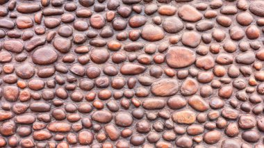 Wall round stones stacked hand built structure close up section brown tone photo of decor exterior outdoors.