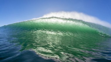 Okyanus dalgası yüz yüze yüzüyor. İçi boş kırılan su gücüyle karşı karşıya geliyor..