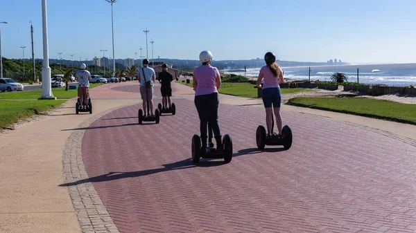 Men Women Unrecognizable Riding Stand Scooters Rear Photograph Beach Ocean — стокове фото