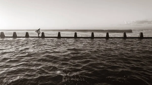 サーフィンボディボーダーサーファーがセピアの風景写真で潮位スイミングプールの壁のエントリから海の波に飛び込むしようと — ストック写真