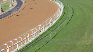 Horse racing closeup  race tracks grass turf and sand poly.