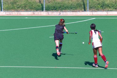 Hokey kız oyuncuları astro sahada top için meydan okuyorlar..