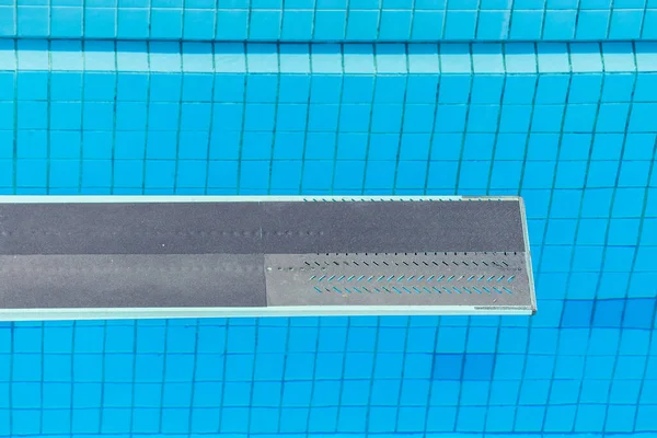 Swimming Pool Diving Board Diver\'s view over blue water.