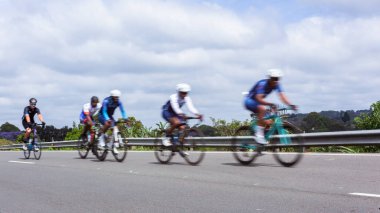 Bisiklet süren beş bisikletçi, bisiklet süren tanınmayan sporcular açık yolda hız bulanıklığı yaşıyorlar..