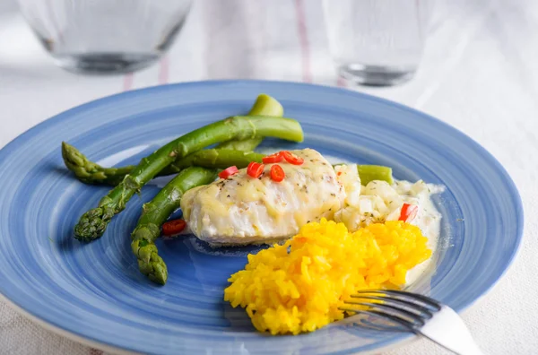 White fish with saffron rice and some cheese on top and aspargus — Stock Photo, Image