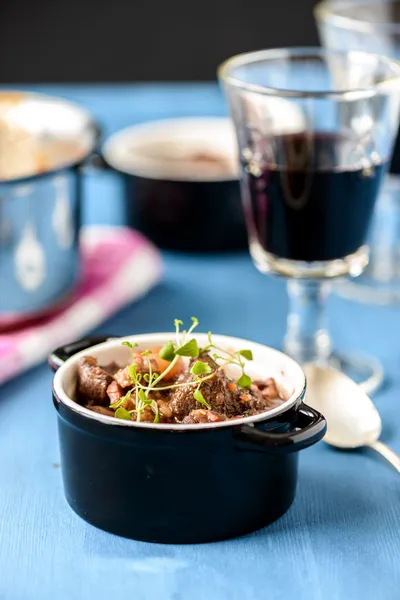 Boeuf bourguignon clásico guiso de ternera francesa en la mesa azul con un —  Fotos de Stock