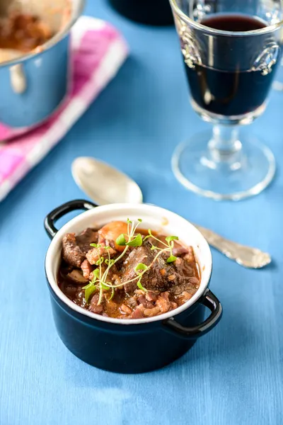 Boeuf bourguignon clásico guiso de ternera francesa en la mesa azul con un —  Fotos de Stock