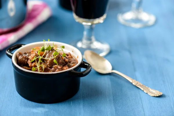 Boeuf bourguignon clássico francês ensopado de carne na mesa azul com um — Fotografia de Stock