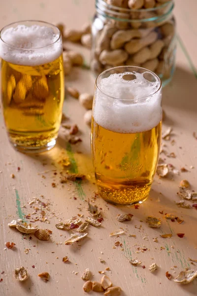 Beer with peanuts on old wood table — Stock Photo, Image