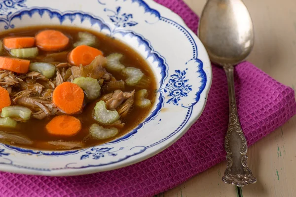 Sopa de frango na velha mesa vintage com cenouras e selery no topo — Fotografia de Stock