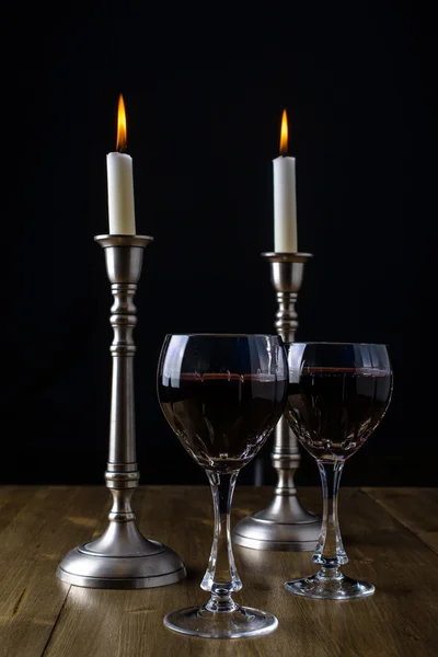 Czerwone wino z świece na stół z drewna — Zdjęcie stockowe