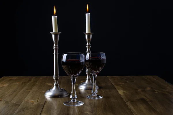 Ahşap masa üstünde mumlar ile kırmızı şarap — Stok fotoğraf