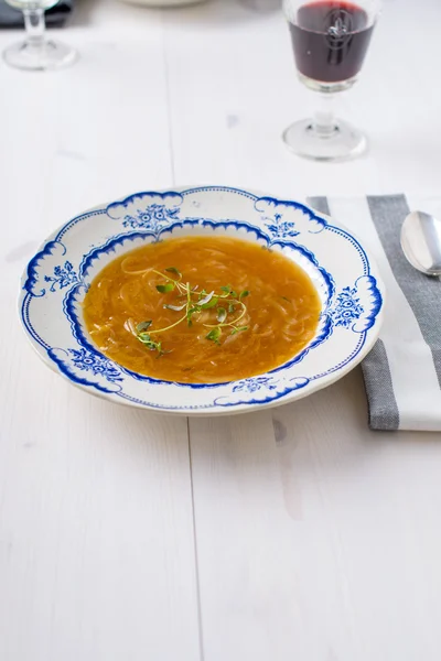 Klassieke Franse uiensoep op een witte houten tafel met sommige rode wi — Stockfoto