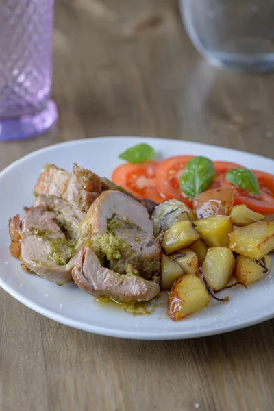 Stuffed pork fillet with tomatoes and basil on the side on an ol — Stock Photo, Image