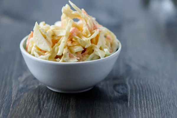 ahşap bir masa üzerinde bir kase salata