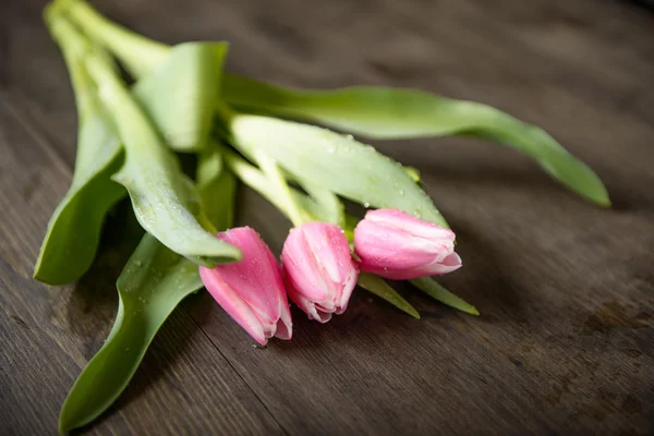 tulpen met sommige water splash op een houten tafel
