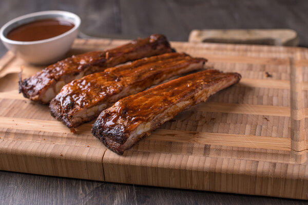 RIbs on a cutting board with BBQ sauce