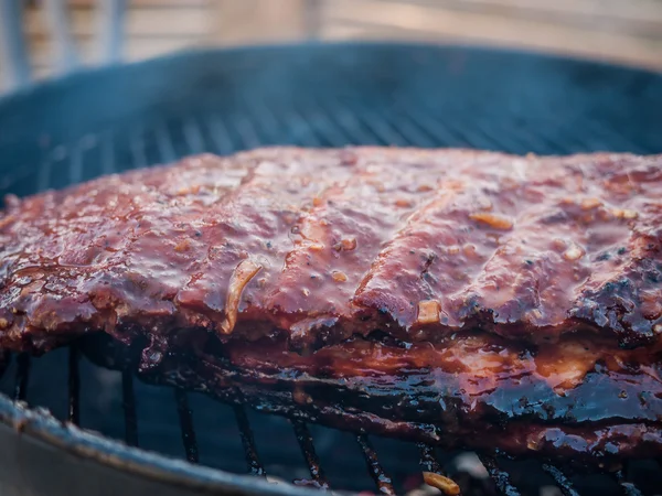 Ribben op de grill met vuur op de zijkant en rook komen — Stockfoto