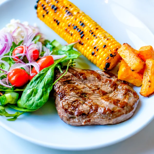 Gegrilde biefstuk met sommige sallad aan de kant en maïs — Stockfoto