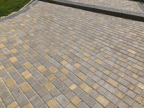 Perspective View of Monotone Gray Brick Stone on The Ground for Street Road. Sidewalk, Driveway, Pavers, Pavement in Vintage Design Flooring Square Pattern Texture Background, house, grass