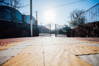 Demir kapılar ve yol kenarındaki çitler kaldırım levhalarından.