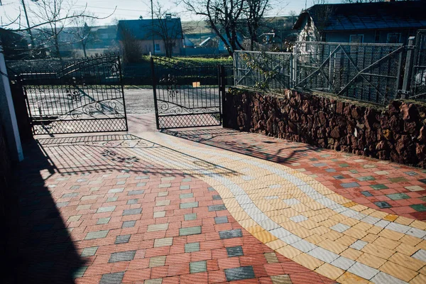 Demir kapılar ve yol kenarındaki çitler kaldırım levhalarından.