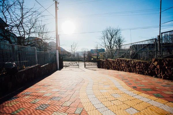 Demir kapılar ve yol kenarındaki çitler kaldırım levhalarından.