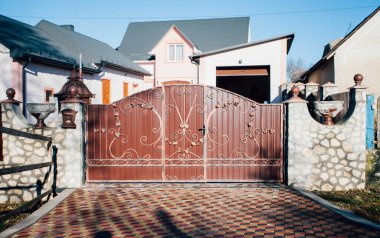 Demir kapılar ve yol kenarındaki çitler kaldırım levhalarından.