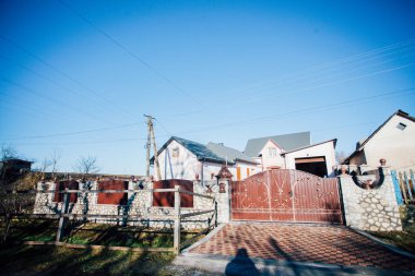 Demir kapılar ve yol kenarındaki çitler kaldırım levhalarından.