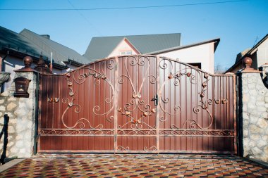 Demir kapılar ve yol kenarındaki çitler kaldırım levhalarından.