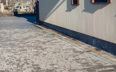 Kenardan gelen suyla yağmur oluğu aşağı akıyor. Taş kiremitlerin etrafında
